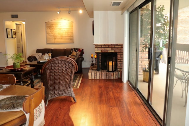 interior space with a fireplace, wood-type flooring, and track lighting