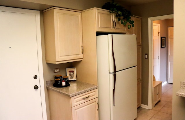 kitchen with light tile patterned flooring and white refrigerator