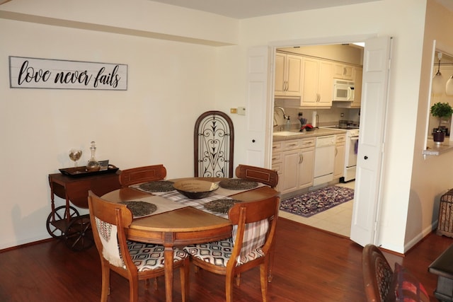 dining area featuring dark wood-type flooring and sink