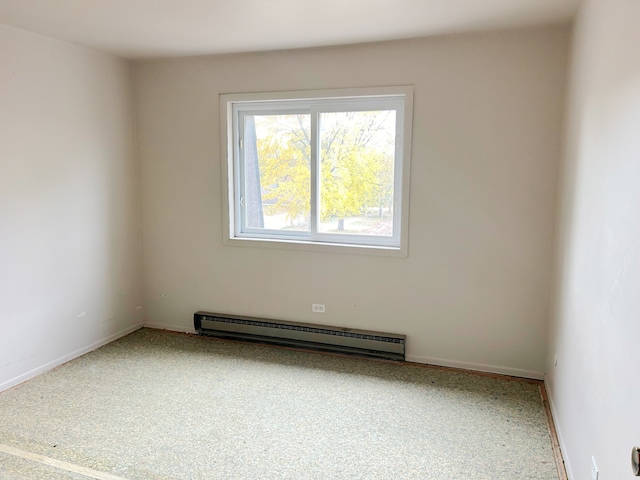 carpeted spare room with a baseboard radiator