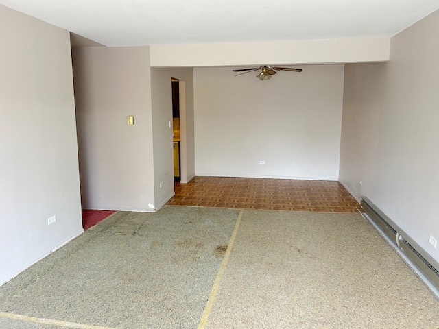 spare room with a baseboard heating unit and ceiling fan