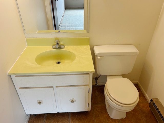 bathroom featuring a baseboard heating unit, vanity, tile patterned floors, and toilet