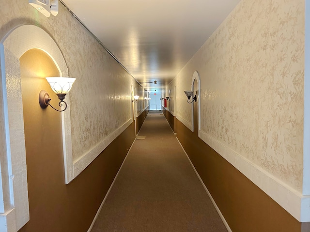 corridor featuring dark carpet