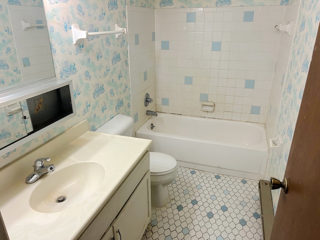 full bathroom featuring tile patterned flooring, vanity, tiled shower / bath combo, and toilet