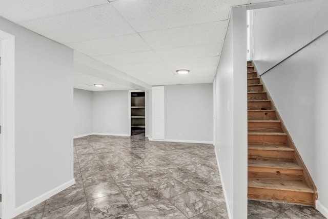 basement with a paneled ceiling