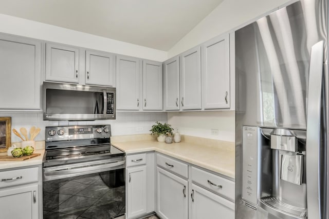 kitchen with decorative backsplash, lofted ceiling, and appliances with stainless steel finishes