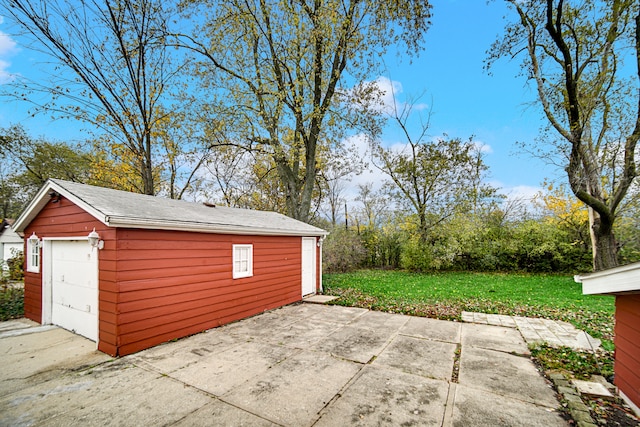 view of patio featuring an outbuilding and a garage