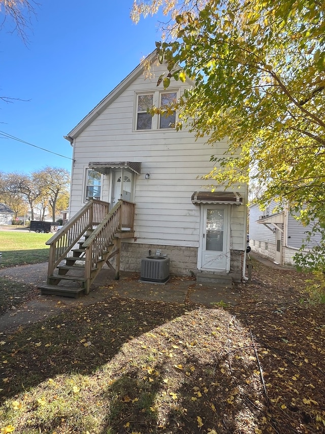 back of house with central AC unit