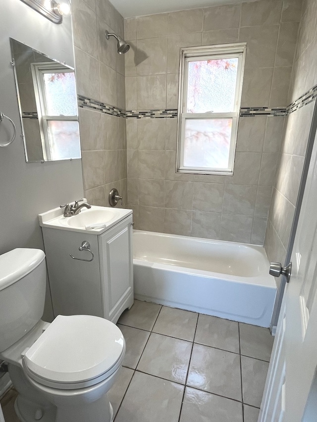 full bathroom featuring tiled shower / bath, vanity, a wealth of natural light, and tile patterned flooring