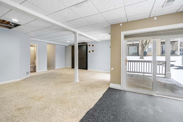 basement with a paneled ceiling and carpet floors