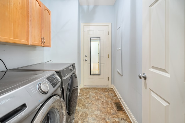 washroom featuring cabinets and independent washer and dryer