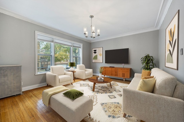 living room with hardwood / wood-style floors, crown molding, and an inviting chandelier