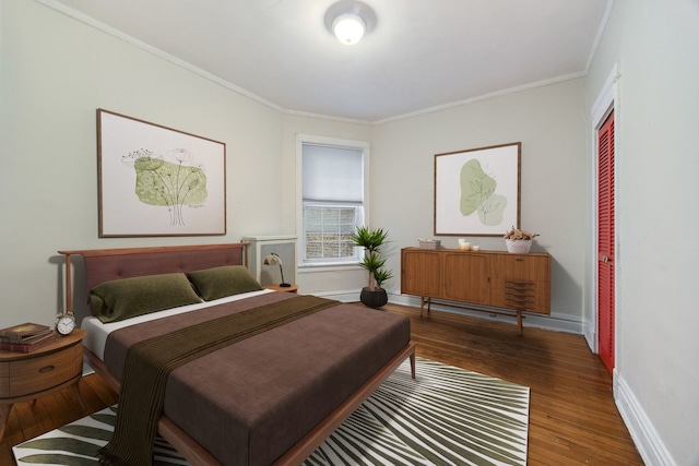 bedroom featuring a closet, hardwood / wood-style flooring, and crown molding