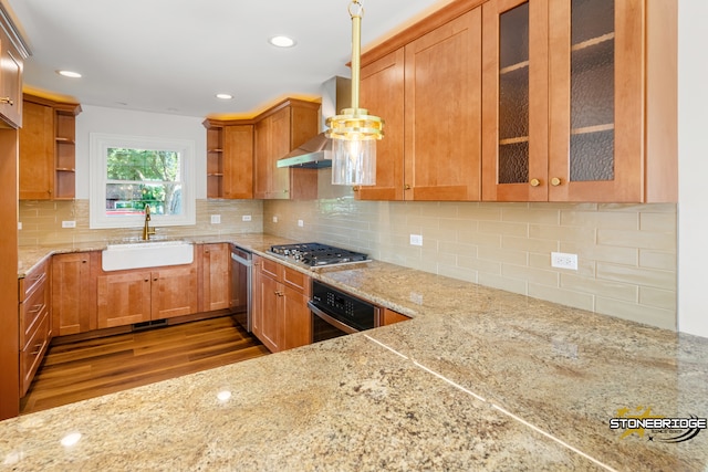 kitchen featuring sink, dark hardwood / wood-style floors, light stone countertops, appliances with stainless steel finishes, and decorative light fixtures