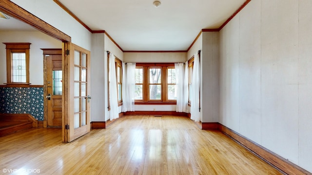 empty room featuring light wood-type flooring and crown molding