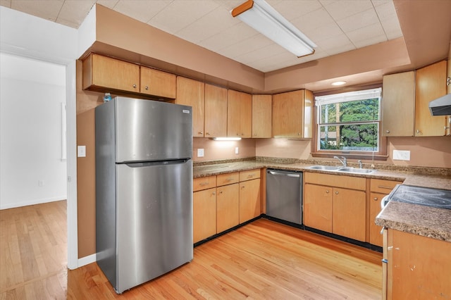 kitchen with stainless steel appliances, light hardwood / wood-style floors, and sink