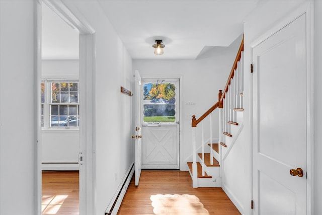 entryway with a baseboard heating unit, a wealth of natural light, and light hardwood / wood-style flooring