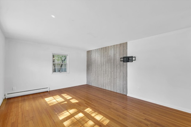 spare room featuring hardwood / wood-style flooring and baseboard heating