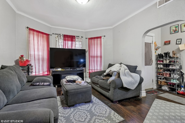 living room featuring dark hardwood / wood-style flooring, a textured ceiling, and ornamental molding