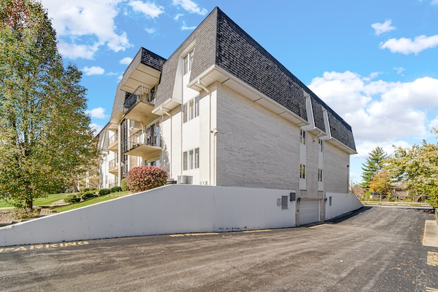 view of property exterior with a garage and a balcony