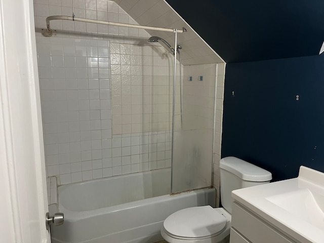 full bathroom featuring vanity, tiled shower / bath combo, toilet, and lofted ceiling