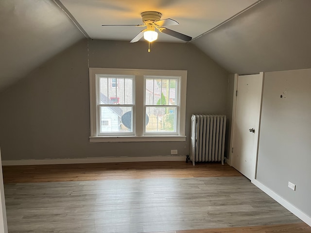 bonus room with light hardwood / wood-style floors, ceiling fan, radiator heating unit, and lofted ceiling