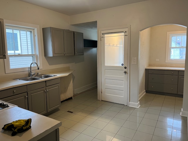 kitchen with gray cabinets, sink, and light tile patterned flooring