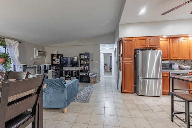 kitchen with tasteful backsplash, a wall mounted AC, light tile patterned flooring, stainless steel appliances, and lofted ceiling