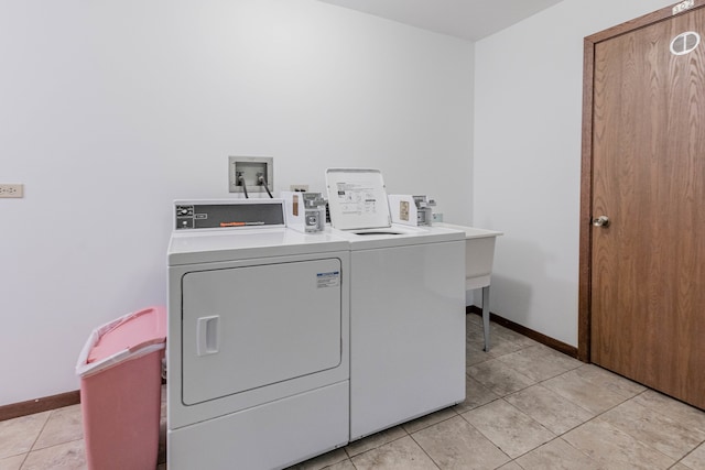 laundry room featuring washing machine and dryer and light tile patterned flooring