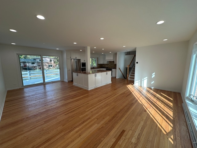 unfurnished living room with wood-type flooring and sink