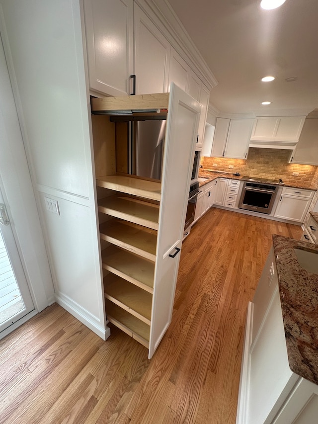 kitchen featuring white cabinetry, stone counters, and light hardwood / wood-style floors