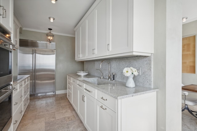 kitchen with crown molding, sink, stainless steel built in fridge, white cabinets, and hanging light fixtures