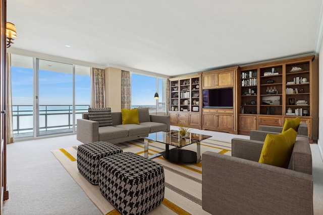 carpeted living room featuring floor to ceiling windows and a water view