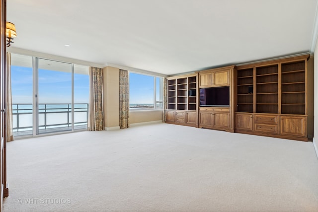 unfurnished living room with carpet flooring and a water view