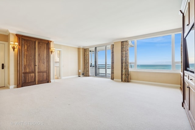 carpeted bedroom with crown molding, a water view, and a view of the beach