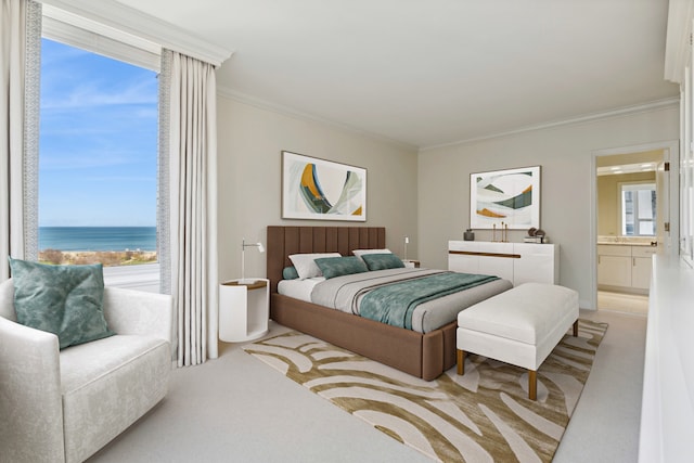 carpeted bedroom with multiple windows, a water view, ornamental molding, and ensuite bath