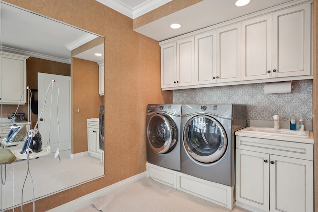 laundry area with separate washer and dryer, crown molding, sink, and cabinets