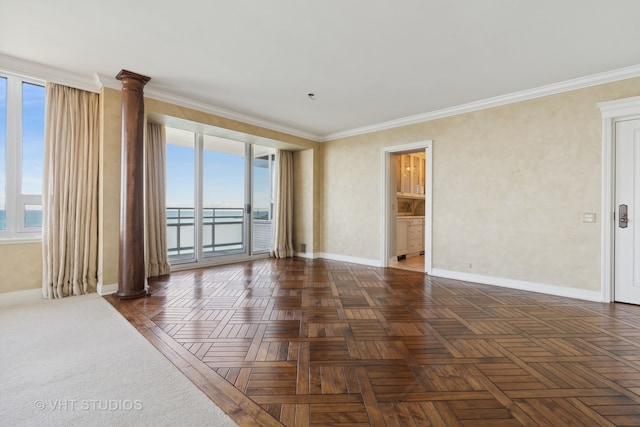 unfurnished room with dark parquet flooring, decorative columns, a wealth of natural light, and ornamental molding