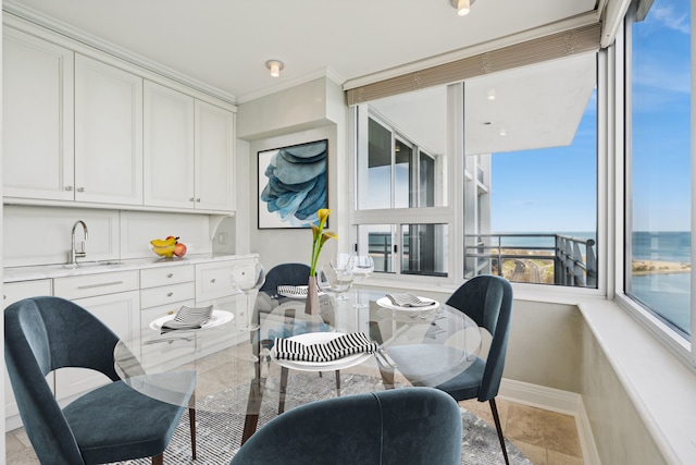 interior space with a water view, crown molding, and sink