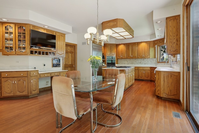 kitchen featuring hardwood / wood-style floors, sink, decorative light fixtures, and a center island