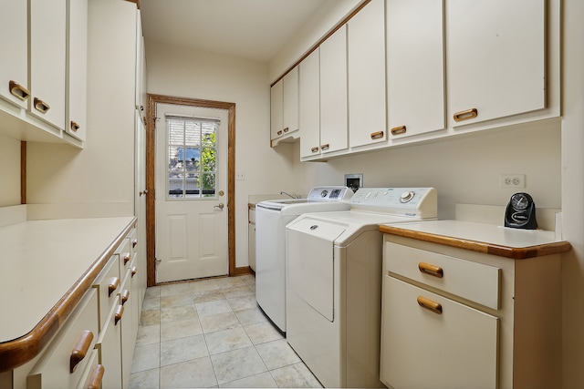 laundry room featuring washer and clothes dryer, cabinets, and light tile patterned floors