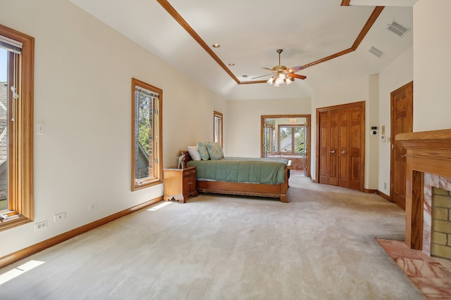 unfurnished bedroom featuring ornamental molding, ceiling fan, a tray ceiling, light colored carpet, and a closet