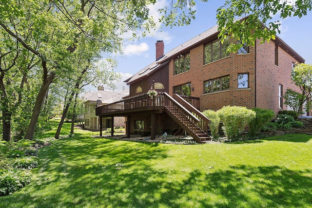 rear view of house featuring a wooden deck and a lawn