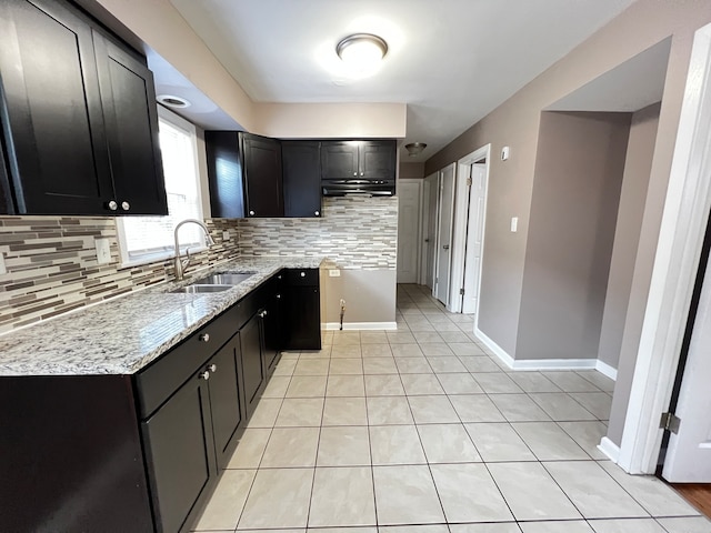 kitchen with decorative backsplash, sink, light stone counters, and light tile patterned floors