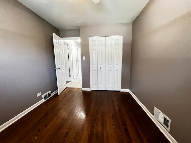 unfurnished bedroom featuring a closet, hardwood / wood-style flooring, and ceiling fan