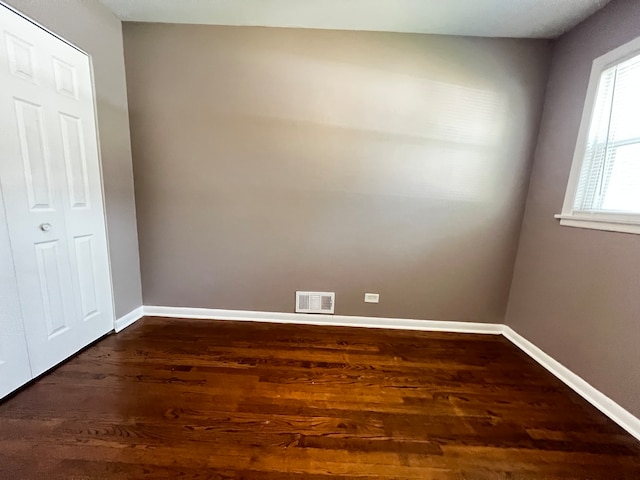 unfurnished bedroom with dark hardwood / wood-style flooring