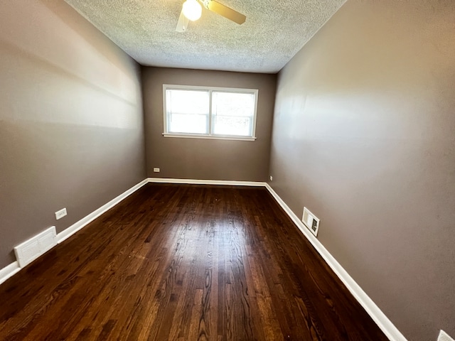 empty room featuring dark wood-type flooring, a textured ceiling, and ceiling fan