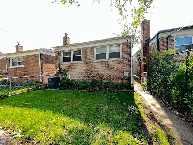 exterior space featuring central AC unit and a front lawn