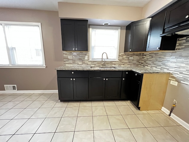 kitchen with light tile patterned flooring, sink, light stone counters, and decorative backsplash