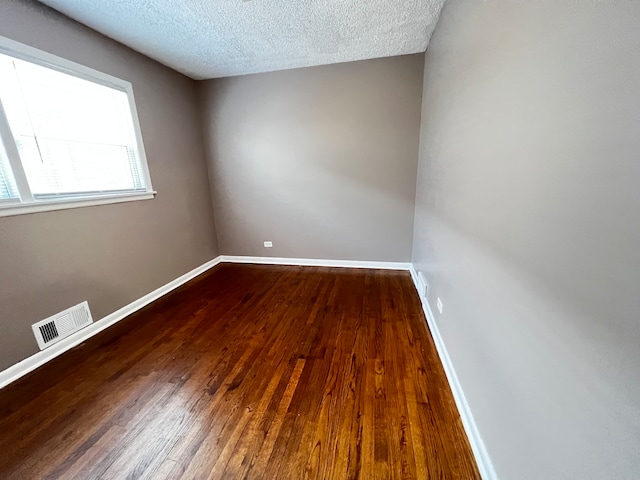 unfurnished room featuring wood-type flooring and a textured ceiling